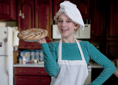 Beautiful young woman with pie for oven