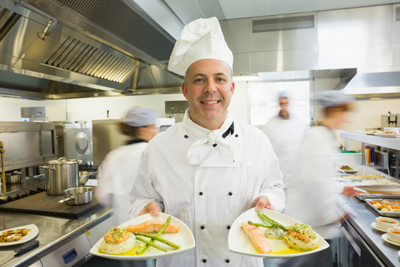 Chef serving two plates of fish