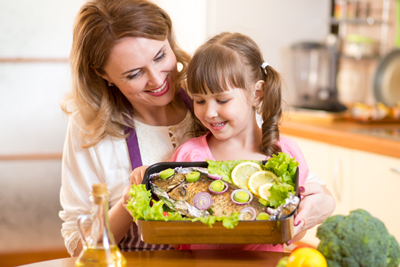 Mum and daughter baking fish