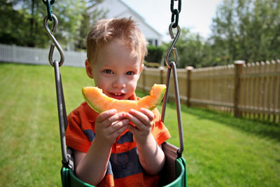 Kid eating rock melon (cantaloupe)
