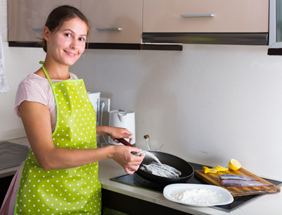 Lady cooking fish