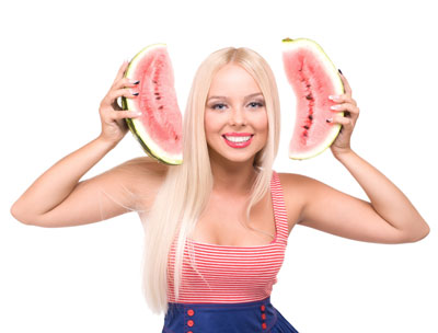 Young woman holding up cut watermelon