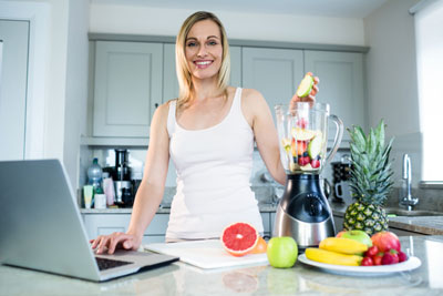 Woman preparing a fruit-juice beverage
