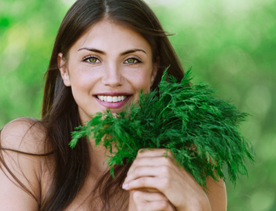 Young woman with bunch of fresh dill