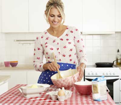 Beautiful young woman preparing dairy products to cook