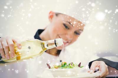 Chef using dressing on salad