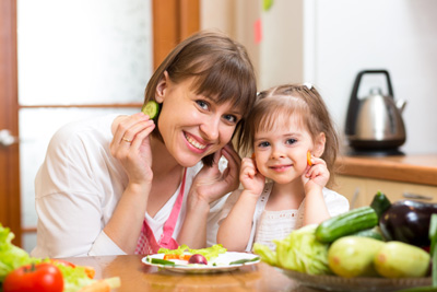 Mum and Daughter making salad dish in kitchen