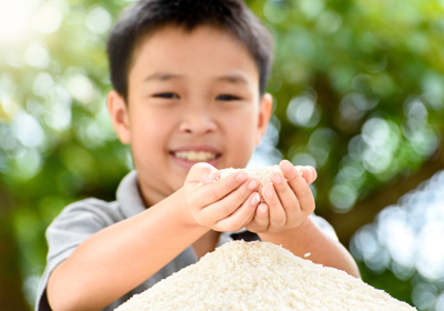 Kid with hands full of rice