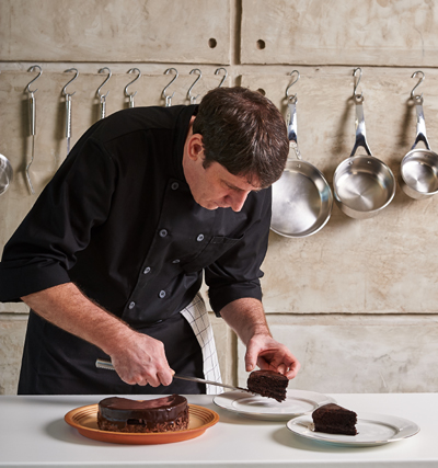 Chef with a chocolate cake on plate